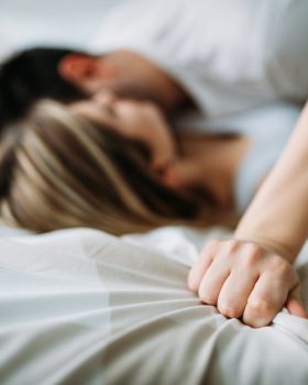 Portrait of young attractive loving couple in bedroom
